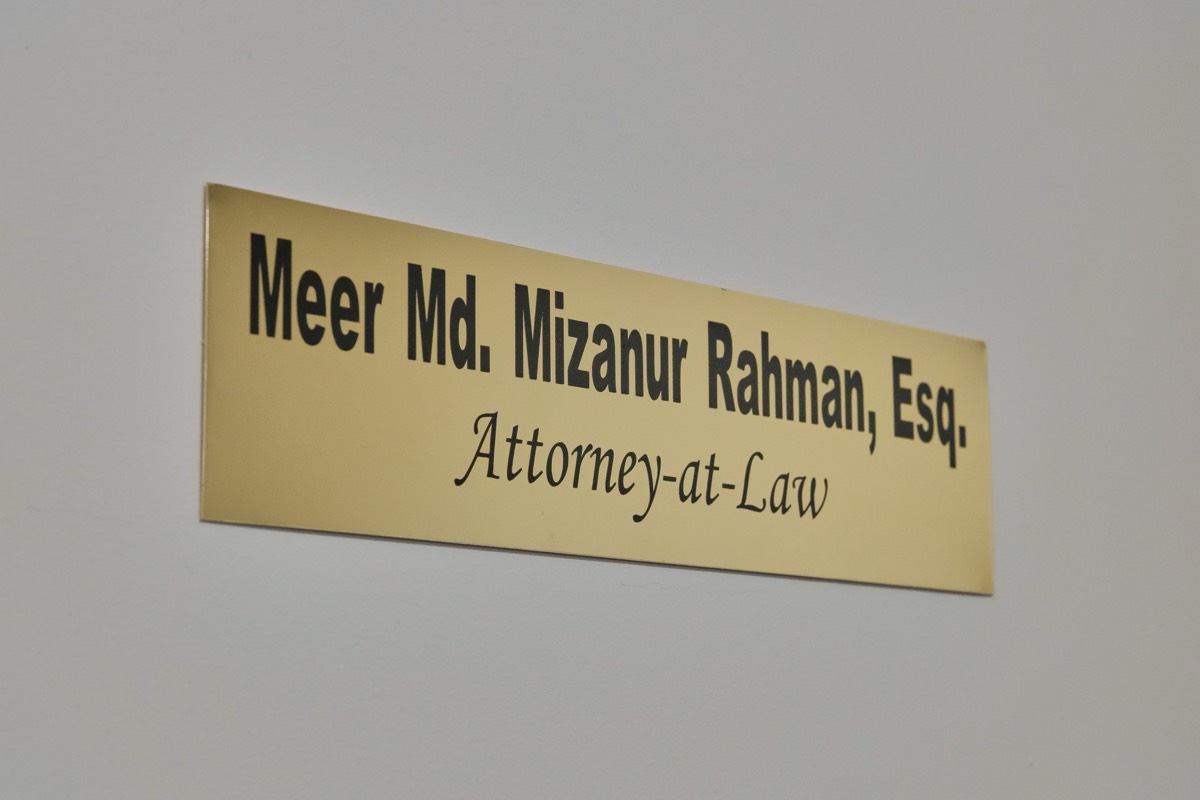 办公室内的铜制门牌，刻有 Meer Md. Mizanur Rahman, Esq. Attorney-at-Law
